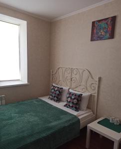 een slaapkamer met een bed met een groene deken en een raam bij Holiday House Rizomylos 