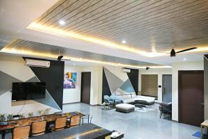 a living room with a couch and a tv at Luxe poolside farmhouse -J House in Hyderabad