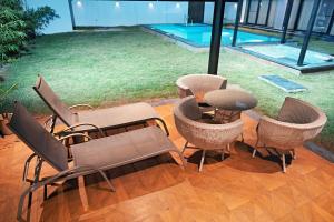 a patio with chairs and a table and a pool at Luxe poolside farmhouse -J House in Hyderabad