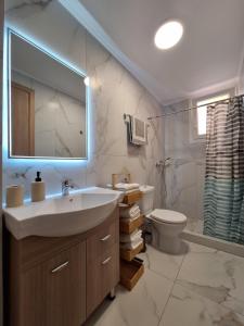 a bathroom with a sink and a toilet and a mirror at Minos Apartments in Skala Marion +22 photos