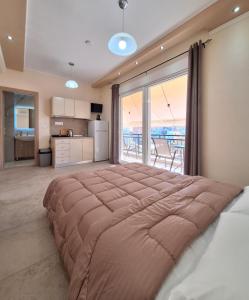 a large bed in a room with a large window at Minos Apartments in Skala Marion