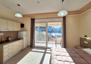 a room with a bed and a kitchen with a large window at Minos Apartments in Skala Marion +21 photos