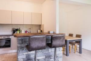 a kitchen with a counter and a table and chairs at Casa Magging un oasi nel verde in Locarno