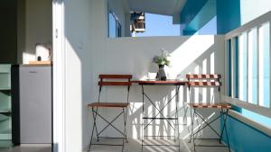 a small balcony with a table and two stools at Three Monkeys Chaweng Beach in Chaweng