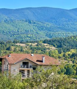 een huis bovenop een heuvel met uitzicht bij Къща за гости Sunrise - Батак in Batak