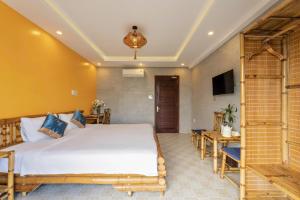 a bedroom with a bed and a desk and a television at Calm House 4 Hoi An in Hoi An +38 photos