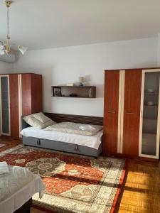 1 Schlafzimmer mit 2 Betten, einem Schrank und einem Teppich in der Unterkunft Levendula vendégház in Verpelét