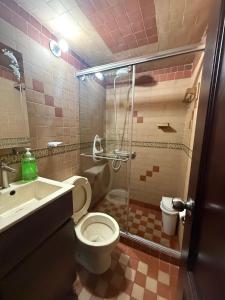 a bathroom with a shower and a toilet and a sink at Monguí Posada Familiar in Duitama +20 photos