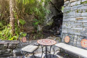 a patio with two chairs and a table at Casa Magging un oasi nel verde in Locarno