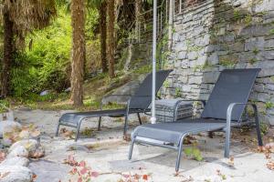 three chairs sitting in front of a building at Casa Magging un oasi nel verde in Locarno +5 photos