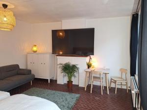 een kamer met een bed, een tafel en een tv bij Appartements Entiers - Centre de Tournai in Tournai