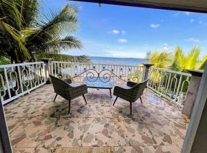 a patio with a table and chairs and the ocean at Casa Vista al Amatique in Puerto Barrios +20 photos