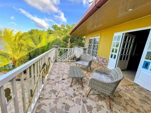 a porch with two chairs and a table at Casa Vista al Amatique in Puerto Barrios