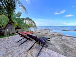 a couple of benches sitting on a patio overlooking the ocean at Casa Vista al Amatique in Puerto Barrios
