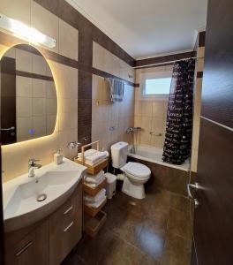 a bathroom with a sink and a toilet and a tub at Minos Apartments in Skala Marion