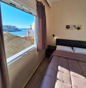 a bedroom with a bed and a large window at Minos Apartments in Skala Marion