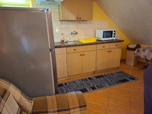 a kitchen with a refrigerator and a microwave at Atticapartament in Kluszkowce