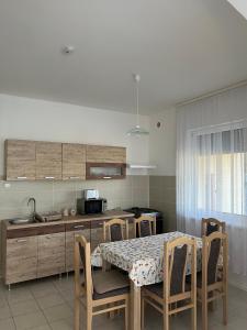 eine Küche mit einem Tisch und einigen Stühlen sowie einem Tisch und einer Küche in der Unterkunft Levendula vendégház in Verpelét