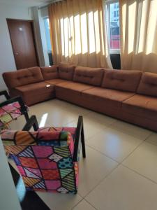 a living room with a brown couch and a chair at Estrela de davi in Goiânia
