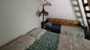 een slaapkamer met twee bedden en een lamp bij Sitio Flor do Coriscão Paraty in Paraty