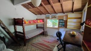een kamer met een stapelbed en een tafel bij Sitio Flor do Coriscão Paraty in Paraty