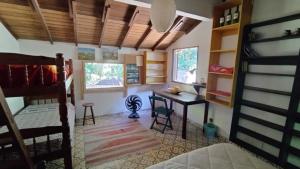 een kamer met een bureau en een slaapkamer met een stapelbed bij Sitio Flor do Coriscão Paraty in Paraty