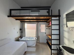 een hoogslaper in een badkamer met een badkuip bij Ofurô com hidromassagem aquecida in Guia Lopes da Laguna