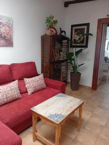 un salon avec un canapé rouge et une table basse dans l'établissement Casa Rural en San Carlos del Valle- Doña Gumersinda, à San Carlos del Valle 103 autres photos