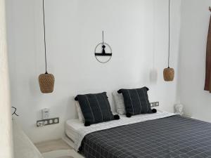 una camera da letto con un letto con cuscini bianchi e neri di L Apothiki a Ios Chora