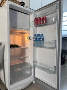 een open koelkast met flessen water erin bij Ofurô com hidromassagem aquecida in Guia Lopes da Laguna