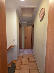 a hallway with a clock on the wall and a door at Fewo LucGa in Zingst +2 photos