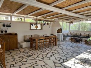 un ampio soggiorno con tavolo e sedie di L Apothiki a Ios Chora