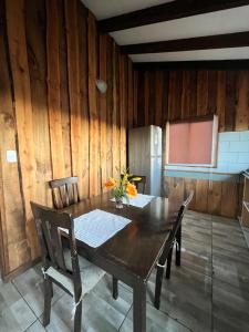 a kitchen with a table and chairs and a refrigerator at Cabaña la Concepción 1 in Cunco