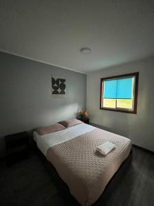 a bedroom with a large bed and a window at Cabaña la Concepción 1 in Cunco