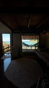 een kamer met een bed en uitzicht op het strand bij Chalé Pé na Areia Por do Sol in Paraty