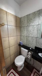 een kleine badkamer met toilet en wastafel bij Chalé Pé na Areia Por do Sol in Paraty +10 foto's