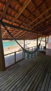 een hangmat op een terras met een strand bij Chalé Pé na Areia Por do Sol in Paraty