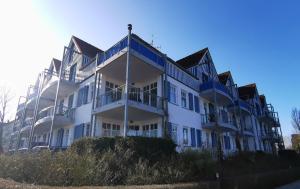 a large white building with blue trim at ruhige 3-Raum-Wohnung "BODDENBLICK" mit Balkon und Terrasse in Zingst