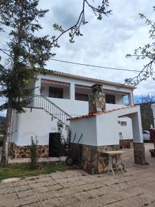a house with a stone fireplace in front of it at Casa Rural Angorrilla in Reolid