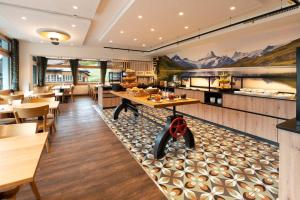 een restaurant met tafels en stoelen en een toonbank bij Jungfrau Lodge, Swiss Mountain Hotel in Grindelwald +43 foto's
