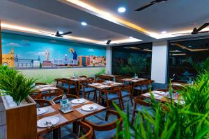 ein Restaurant mit Holztischen und -stühlen und einem Wandbild in der Unterkunft Hotel Aerotel Airport Zone,Shamshabad in Shamshabad