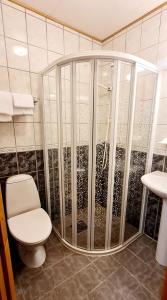 een badkamer met een douche, toilet en wastafel bij Sauda Bed & Breakfast in Sauda