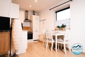 een keuken en eetkamer met een tafel en stoelen bij Ferienwohnung See Glück in Wunstorf