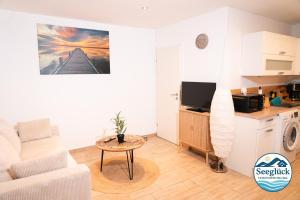 een woonkamer met een bank en een tafel bij Ferienwohnung See Glück in Wunstorf