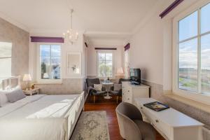 een slaapkamer met 2 bedden en een bureau en een kamer bij Hotel Villa Wahnfried Thiessow in Thiessow