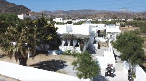 een luchtzicht op een wit huis met bomen en bergen bij Villa Campos Yalos beach in Ios Chora