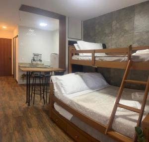 a room with three bunk beds and a table at Pousada Verde Serrath - Muriqui in Vila Muriqui +43 photos