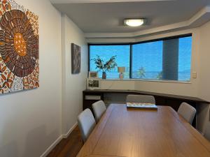 een eetkamer met een tafel en een groot raam bij 181 The Esplanade in Cairns +64 foto's