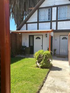 een huis met een veranda en een tuin met gras bij Motherhome in Melipilla