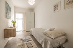 a bedroom with a bed and a table and a window at Appartamento Garden in Riccione